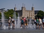 People cool off in the water fountains by the Scoop during a heatwave, in London.