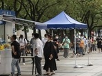 Office workers line up at a Covid testing booth in downtown Shanghai.&nbsp;