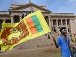 A man wears a headband with a slogan against interim Sri Lankan President Ranil Wickremesinghe as he waves the Sri Lankan national flag near the Presidential secretariat in Colombo on Sunday.