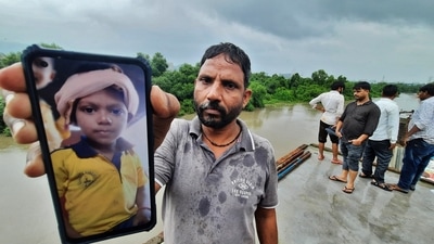 Rishi Usva’s father holding the photo of his deceased son. The body of the seven-year-old boy who drowned in Thane creek last week was found in Airoli on Monday. (PRAFUL GANGURDE/HT PHOTO)