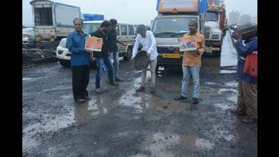 Irked by the poor condition of roads, a commuter got out of his car and protested against the potholes and poor road condition on Monday morning at Majiwada flyover in Thane. He started filling the potholes on his own and was joined by a few other commuters in his protest. (PRAFUL GANGURDE/HT PHOTO)