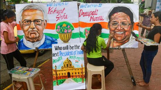 Artists paint portraits of presidential candidates Droupadi Murmu and Yashwant Sinha, ahead of the Presidential elections in Mumbai on Sunday. (PTI PHOTO.)