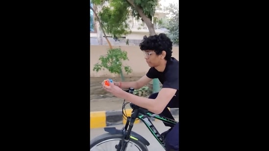 The image, taken from the video posted on Instagram by Guinness World Records, shows the man solving the Rubik's Cube on a bicycle.&nbsp;(Instagram/@guinnessworldrecords)