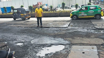 Dhaval Shah, a Lokhandwala resident, points to potholes near DN Nagar Metro station HT Photo Dhaval Shah, a Lokhandwala resident, points to potholes near DN Nagar Metro station HT Photo