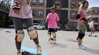 Mina Zhao, 40, teaches a member of her women's club how to use a skateboard, during a practise session in Beijing, China.&nbsp; (REUTERS)