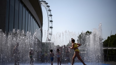 Children cool off in a water fountain during a heatwave, in London, Britain on Tuesday. (REUTERS)