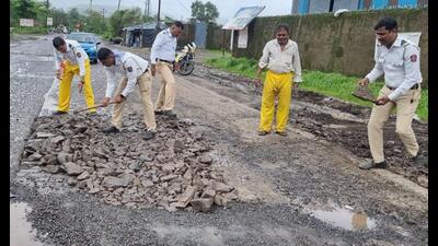 Taloja traffic police filling potholes on the Taloja MIDC road. (BACHCHAN KUMAR/HT PHOTO)