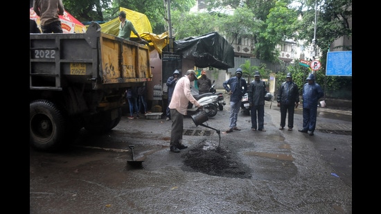 PMC workers repairing potholes at Shukrawar peth on Tuesday. (HT PHOTO)