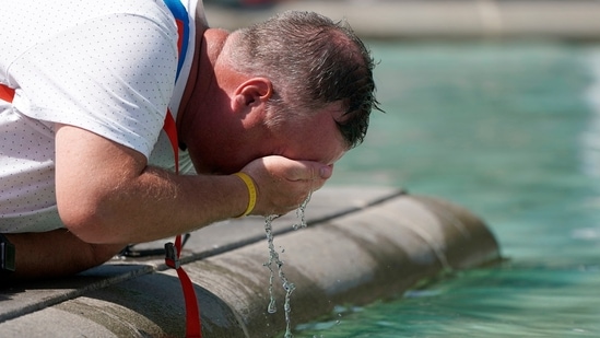 A man refreshes his face at a fountain in Trafalgar Square in central London, Tuesday.(AP)