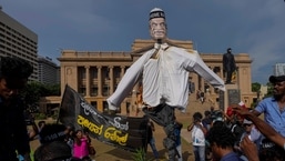 Manifestantes queimam uma efígie do presidente e primeiro-ministro em exercício Ranil Wickremesinghe do lado de fora do gabinete do presidente enquanto exigem sua renúncia em Colombo, Sri Lanka. 