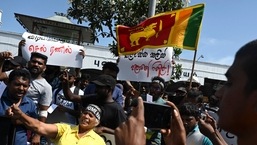 Manifestantes gritam slogans contra o presidente interino do Sri Lanka, Ranil Wickremesinghe, durante um protesto em frente à estação ferroviária Fort, em Colombo.  (Foto de Arun SANKAR/AFP)