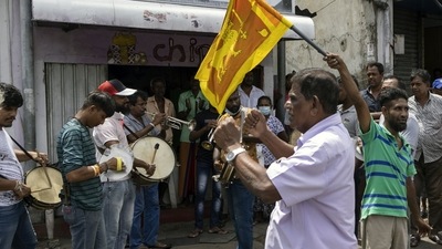 People play drums to celebrate after Wickremesinghe was chosen as the President. (Bloomberg) People play drums to celebrate after Wickremesinghe was chosen as the President. (Bloomberg)