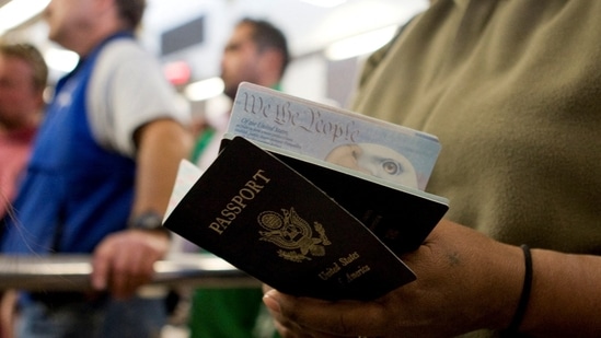 A pedestrian holds passports of the United States (REUTERS/Fred Greaves/File Photo)