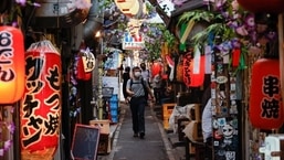 People wearing protective masks walk at a Japanese Izakaya pub alley, amid the coronavirus disease (Covid-19) outbreak, in Tokyo, Japan 