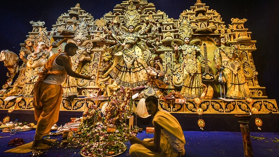 A Hindu priest performs rituals before the idol of Goddess Durga at a community pandal, in Kolkata. Officials of community committees organising big-budget Durga Puja pandals in the city are in hope that Covid situation would not deteriorate so that they can make the entrance more accessible. &nbsp;(PTI Photo/Swapan Mahapatra)