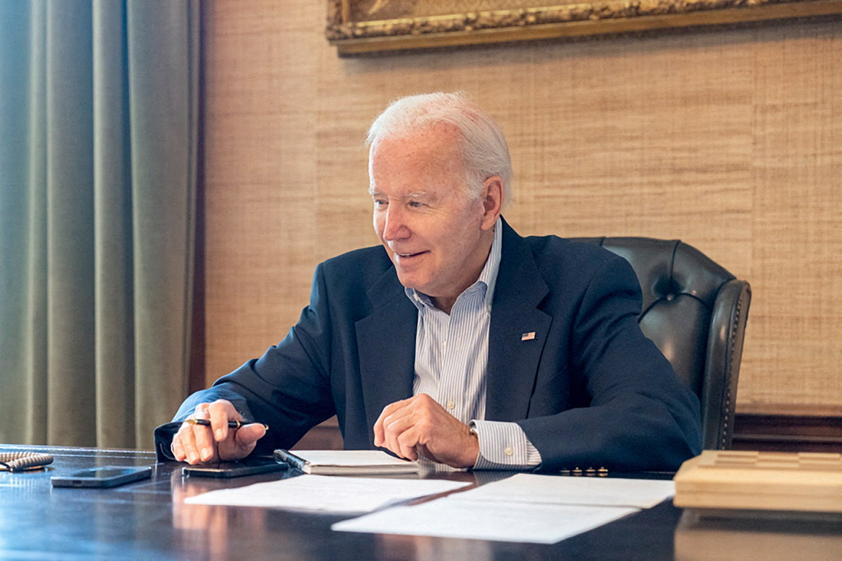 Biden, who tested positive for Covid while experiencing mild symptoms, sits at his desk in the White House residence. (REUTERS)