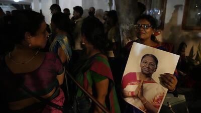 A Santhali tribal woman holds a photograph of India's newly president elect Droupadi Murmu, who also belong to the same tribe, waits with others to congratulate her in New Delhi . (AP) A Santhali tribal woman holds a photograph of India's newly president elect Droupadi Murmu, who also belong to the same tribe, waits with others to congratulate her in New Delhi . (AP)