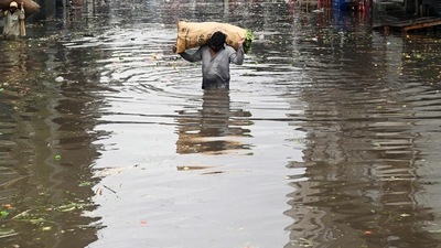 A vendor carries a sack of leafy vegetables wading across a flooded market place after heavy rainfall in Lahore. (AFP) A vendor carries a sack of leafy vegetables wading across a flooded market place after heavy rainfall in Lahore. (AFP)