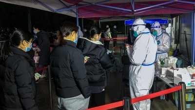 Students queueing to undergo tests for the Covid-19 coronavirus with their parents in Ningbo.