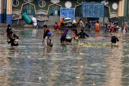 People pick vegetables from water at a flooded market place after heavy rainfall in Lahore. (AFP) People pick vegetables from water at a flooded market place after heavy rainfall in Lahore. (AFP)