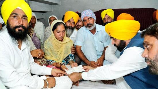 Punjab chief minister Bhagwant Singh handing over a cheque for <span class='webrupee'>₹</span>1 crore to the wife of the soldier at Lauhuke Kalan in Zira on Friday. (HT Photo)