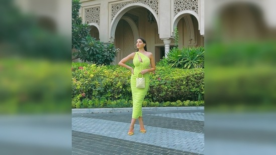 The Moroccan beauty set the temperature soaring as she stepped out in this pastel green midi body-hugging cut-out one-shoulder. She teamed her look with a small shimmery handbag and yellow stilettoes.(Instagram/@norafatehi)
