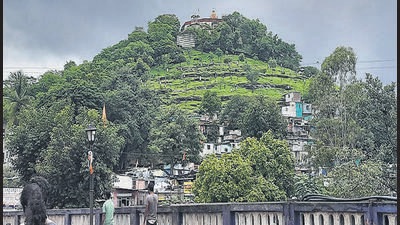 The rain-drenched greenery of Parvati hills stand out as bystanders look over. (HT PHOTO)