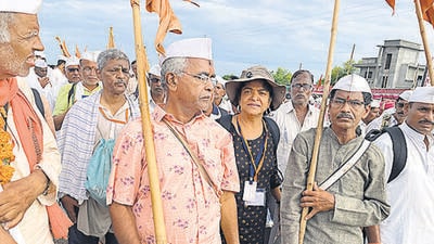Nandini Dias walking with the flag bearers leading the Yatra, followed by chanters, dholak players and cymbal players. Nandini Dias walking with the flag bearers leading the Yatra, followed by chanters, dholak players and cymbal players.