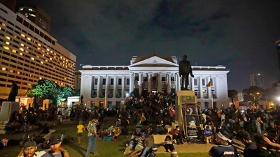 Protesters sit and walk around after storming in at the Sri Lankan president's office, in Colombo, Sri Lanka. (AP) Protesters sit and walk around after storming in at the Sri Lankan president's office, in Colombo, Sri Lanka. (AP)