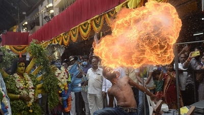Performers dressed as Hindu goddesses Maha Kali perform next to a man performing a fire breathing stunt during the Bonalu festival procession at the Sri Ujjaini Mahakali Temple in Secunderabad, the twin city of Hyderabad. (AFP)
