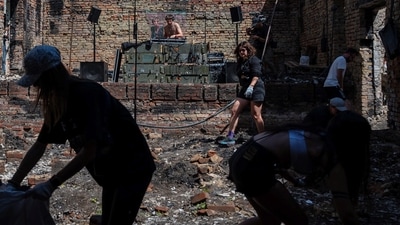 DJ performs while volunteers remove debris from the House of a Culture in the village of Yahidne, which was heavily damaged during Russia's attack on Ukraine, in Chernihiv region. Members of the volunteers' movement Repair Together travel over regions, which were under Russian occupation and help local residents to clean up damaged buildings under accompaniment of electronic music. (REUTERS)