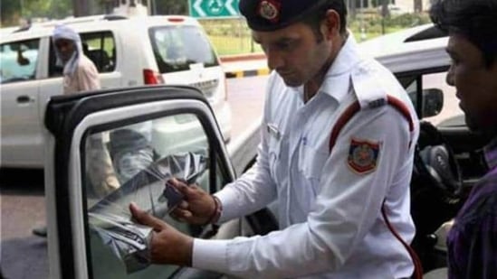 A file photo of a traffic cop issuing challan to a commuter.