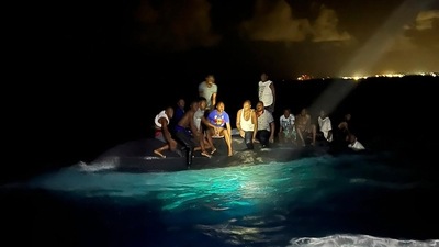 In this photo provided by the Royal Bahamas Defense Force, survivors sit on a capsized boat as they are about to be rescued near New Providence in the Bahamas, early Sunday. ((Royal Bahamas Defense Force via AP)) In this photo provided by the Royal Bahamas Defense Force, survivors sit on a capsized boat as they are about to be rescued near New Providence in the Bahamas, early Sunday. ((Royal Bahamas Defense Force via AP))