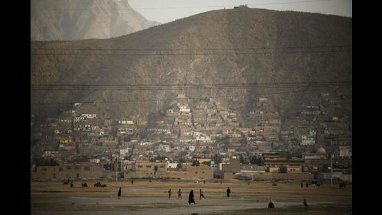 Children play football at the now dry Hashmat Khan Lake in Kabul on July 20, 2022. (AFP)