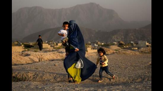 Walking past a cemetery in Kabul on July 19, 2022. (AFP)