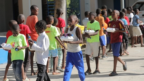 Haitian children who escaped violence in the town of Cite-Soleil line up to receive food while they take refuge at a school, in Port-au-Prince, Haiti, July 22, 2022. (REUTERS)