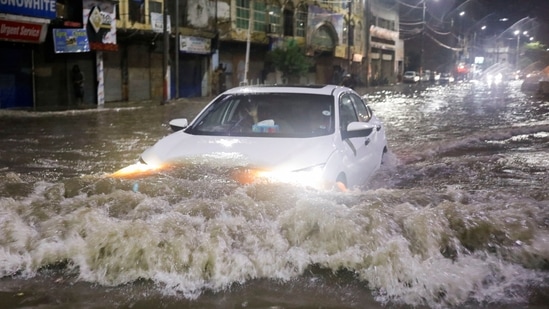 A vehicle drives along a flooded street, following heavy rains during the monsoon season in Karachi, Pakistan.(REUTERS)