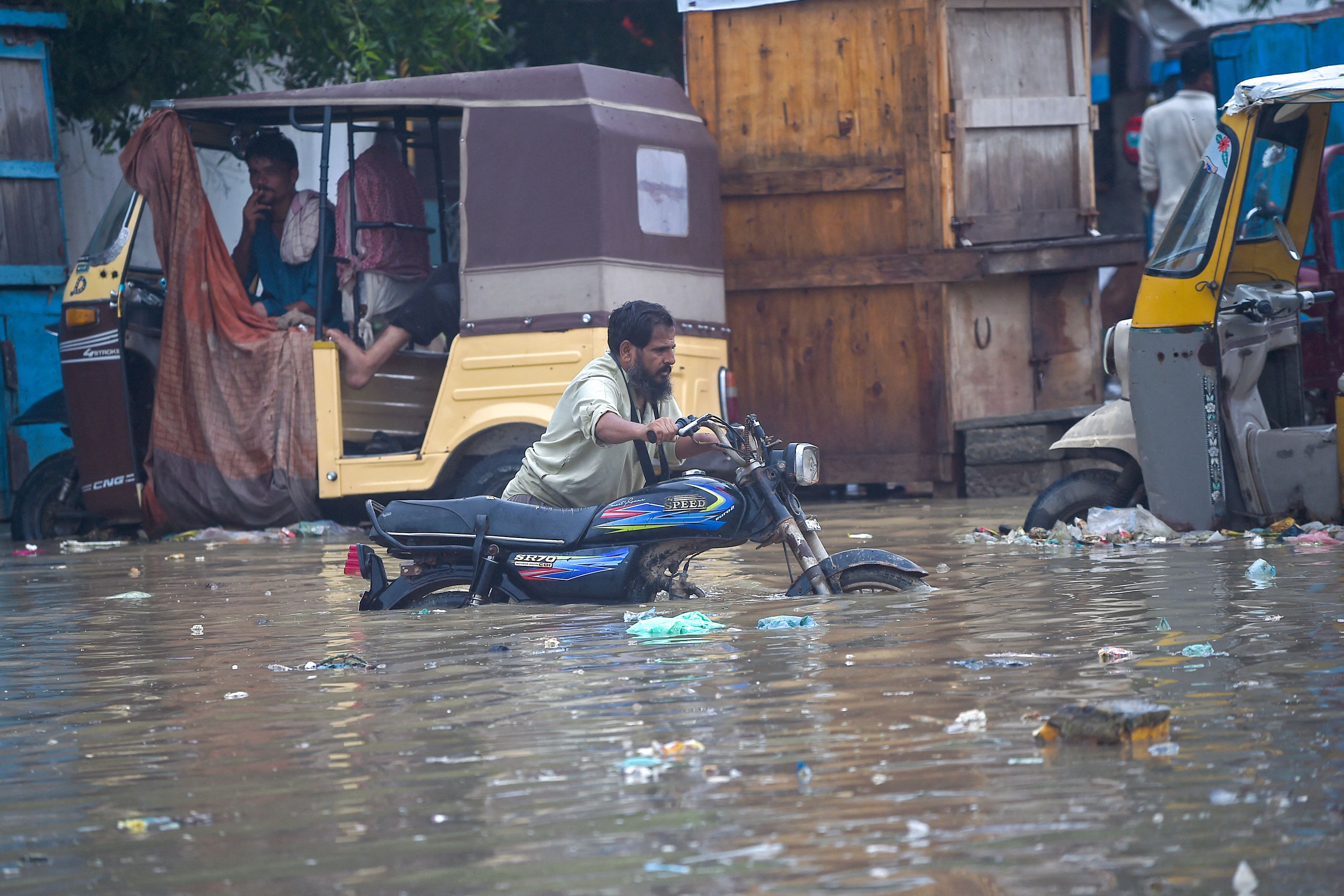 A man pushes his motorbike through a flooded street after heavy monsoon rainfall in Karachi. (AFP) A man pushes his motorbike through a flooded street after heavy monsoon rainfall in Karachi. (AFP)