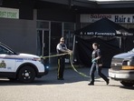 An RCMP officer moves police tape near a tent covering a body at one of three locations being investigated in regards to multiple shootings in Langley, British Columbia. An RCMP officer moves police tape near a tent covering a body at one of three locations being investigated in regards to multiple shootings in Langley, British Columbia.