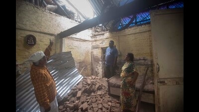 (From left) Ramesh Navgire, Shripad and Surekha Navgire at their residence showing the part of their house that collapsed at Guruwar peth on Tuesday, (Pratham Gokhale/HT Photo)