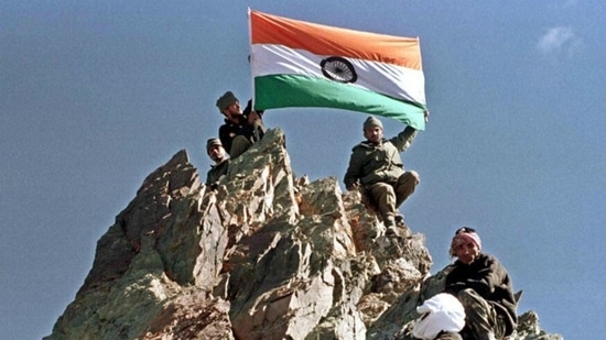 Indian Army hoist national flag from a peak in Drass after it was recaptured during the first week of July 1999.(AFP)