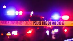 Accident or crime scene cordon tape, police line do not cross. It is nighttime, emergency lights of police cars flashing blue, red and white in the background. (Getty Images/iStockphoto)