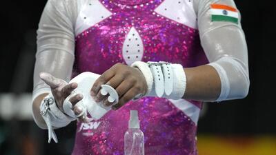 An athlete from India prepares her hands before using the uneven bars in a gymnastics training session ahead of the Birmingham 2022 Commonwealth Games in Birmingham, England, Wednesday, July 27, 2022. The Commonwealth Games will start on Thursday, July 28. (AP Photo/Kirsty Wigglesworth) (AP) An athlete from India prepares her hands before using the uneven bars in a gymnastics training session ahead of the Birmingham 2022 Commonwealth Games in Birmingham, England, Wednesday, July 27, 2022. The Commonwealth Games will start on Thursday, July 28. (AP Photo/Kirsty Wigglesworth) (AP)