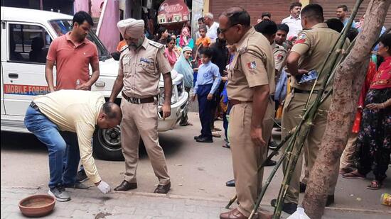 Police inspecting the spot where a shopkeeper was stabbed to death by his business rival at Bapu Dham Colony in Chandigarh on Wednesday. (HT Photo)