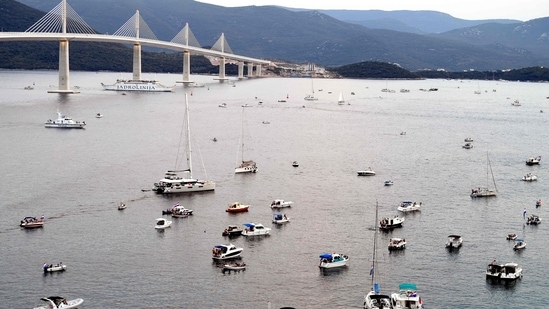 People gather on boats by the newly built "Peljesac" bridge in Komarna to attend its opening ceremony. The bridge connects central and Southern parts of Croatian Adriatic coast, via Peljesac peninsula. The bridge linking Peljesac peninsula with the Croatian mainland has been widely regarded as one of the country's most ambitious infrastructure projects since Zagerb declared independence from Yugoslavia in 1991. &nbsp;(Photo by ELVIS BARUKCIC / AFP)