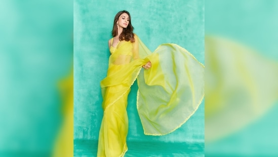 Vaani Kapoor teamed her solid yellow saree featuring a thin embroidered border with a sleeveless bralette blouse.(Instagram/@_vaanikapoor_)
