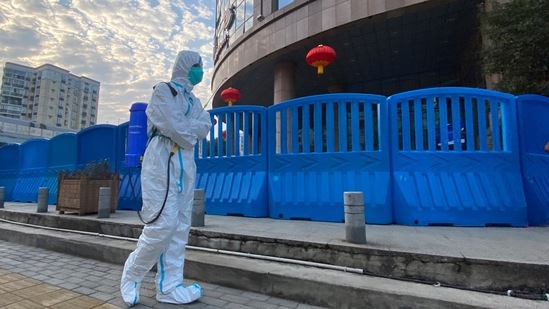 A worker in protectively overalls and carrying disinfecting equipment walks outside the Wuhan Central Hospital, China. (AP Photo/Ng Han Guan, File)