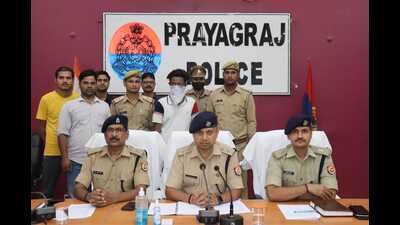 The team of Prayagraj police officers with the 18-year-old (face covered), the only adult among the 11 students arrested for throwing crude bombs. (HT Photo)