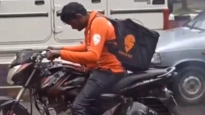 Swiggy delivery agent waits without raincoat at traffic signal (Twitter/@ipskabra)