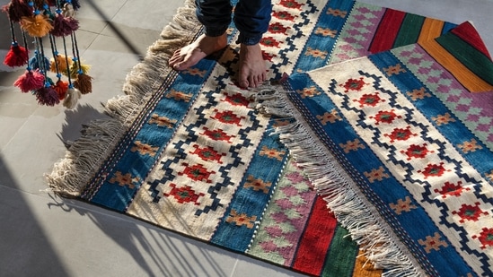 In an interview with HT Lifestyle, Vansikha Nahata (CEO of The June Shop) and Disha Jaiswal (Partner at Qaaleen) told Zarafshan Shiraz, “The finest sort of rug to choose depends on where you want to put it and how much wear and tear it will endure.  If you want a little rug to fit neatly under a coffee table, a longer pile rug is fine, but if you want an area rug to cover the whole of your living room floor, a shorter pile rug is better.  Hence, there's no quicker way to transform the living space than by laying down a rug.  A simple floor covering, perfect for anchoring your seating arrangement, may shift the tempo of the area from vibrant to cool (or vice versa) faster than you can say "refresh."They suggested a few ideas to help you elevate the look of your living room with the help of rugs:  (Photo by Sina Saadatmand on Unsplash)